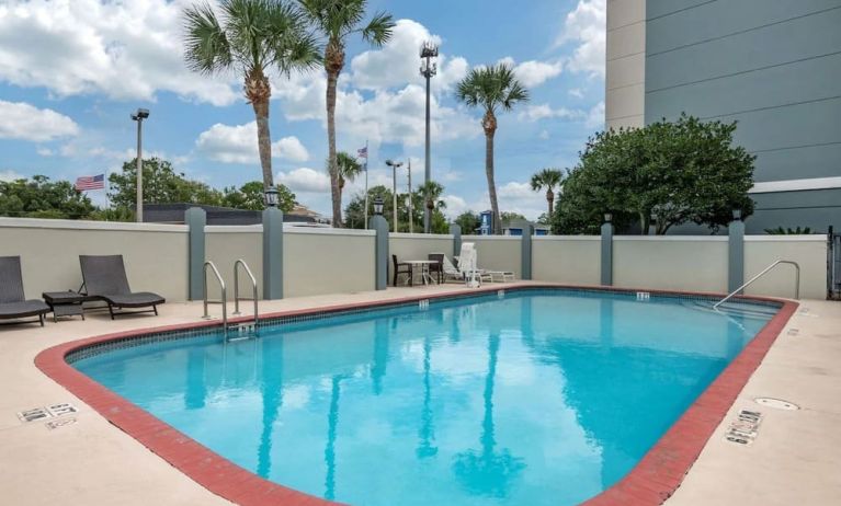 Outdoor pool with loungers at Comfort Suites Baymeadows Near Butler Blvd.