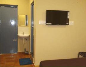 Day room with TV and private bathroom at The Nisarga Residency.