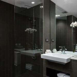 Guest bathroom with shower at Rydges Sydney Airport Hotel.