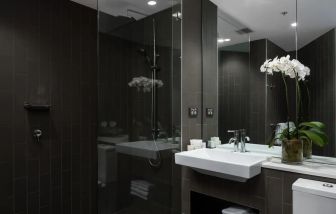 Guest bathroom with shower at Rydges Sydney Airport Hotel.