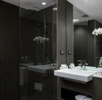 Guest bathroom with shower at Rydges Sydney Airport Hotel.