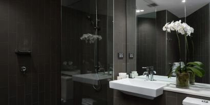 Guest bathroom with shower at Rydges Sydney Airport Hotel.