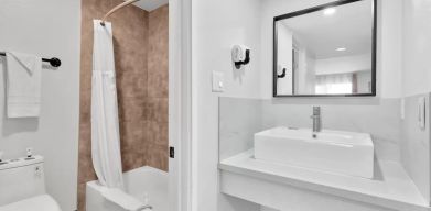 Guest bathroom with shower at Tradewinds Motel.