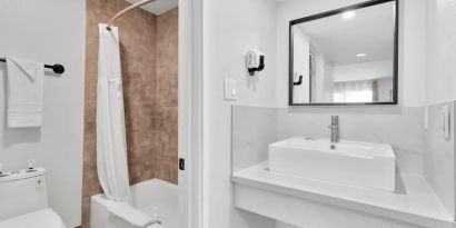 Guest bathroom with shower at Tradewinds Motel.