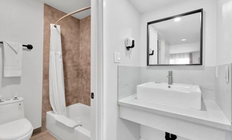 Guest bathroom with shower at Tradewinds Motel.