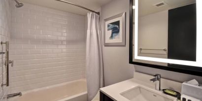 Guest bathroom with shower at Four Points By Sheraton Boston-Newton. 