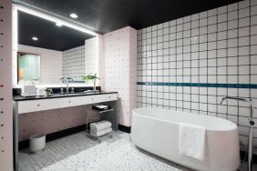 Spacious bathroom with bath and shower at Graduate By Hilton New York.