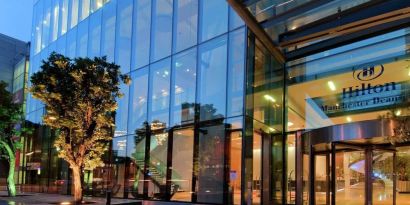 Hotel exterior at night at Hilton Manchester Deansgate.