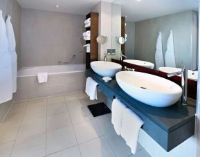 Guest bathroom with shower and bath at Hilton Manchester Deansgate.