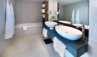 Guest bathroom with shower and bath at Hilton Manchester Deansgate.