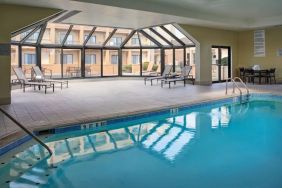 Sonesta Select Indianapolis Carmel’s indoor pool has loungers and chairs nearby.