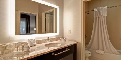 Guest bathroom with shower and tub at Homewood Suites By Hilton Newark-Cranford.