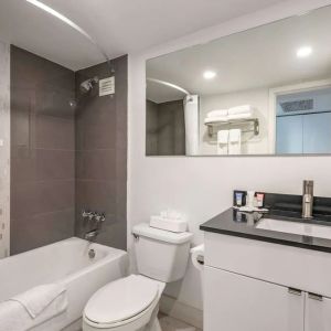 Guest bathroom with shower and bath at Ramada Plaza Marco Polo Beach Resort.