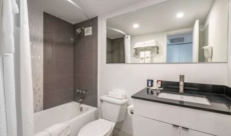 Guest bathroom with shower and bath at Ramada Plaza Marco Polo Beach Resort.