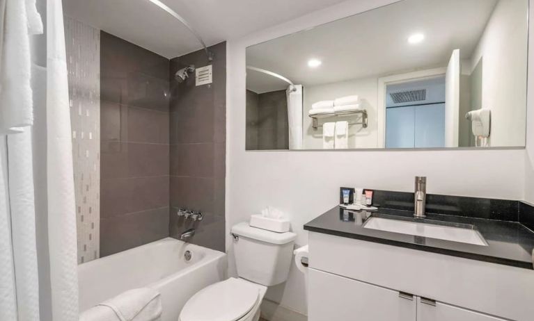 Guest bathroom with shower and bath at Ramada Plaza Marco Polo Beach Resort.