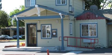 Hotel exterior and parking at North Bay Inn.