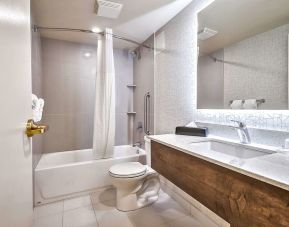 Guest bathroom with shower at Comfort Inn And Suites Calgary South.