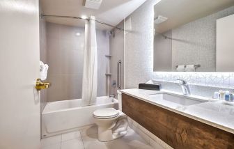 Guest bathroom with shower at Comfort Inn And Suites Calgary South.