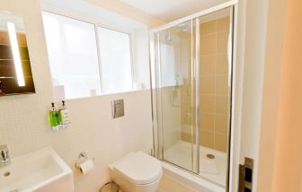 Guest bathroom with shower at The Wesley Euston Hotel.