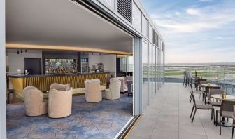 Outdoor chairs near the bar at Hilton Garden Inn London Heathrow Terminals 2 And 3.