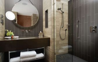 Guest bathroom with shower at Hilton London Bankside. 