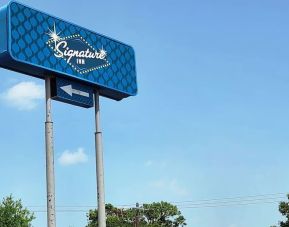 Hotel exterior and sign board at Signature Inn Houston Galleria.