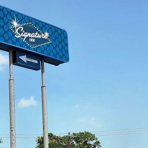 Hotel exterior and sign board at Signature Inn Houston Galleria.