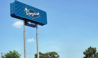 Hotel exterior and sign board at Signature Inn Houston Galleria.