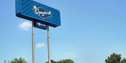 Hotel exterior and sign board at Signature Inn Houston Galleria.