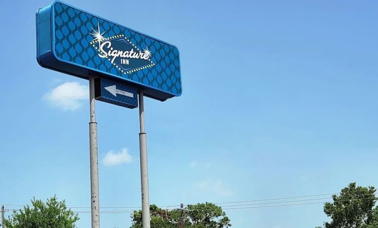 Hotel exterior and sign board at Signature Inn Houston Galleria.