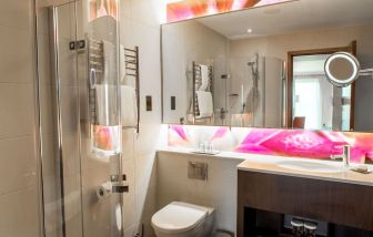 Guest bathroom with shower at Hilton London Heathrow Airport Terminal 5. 