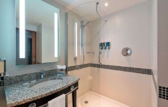 Guest bathroom with shower at Hampton By Hilton London Luton Airport.