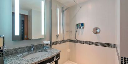 Guest bathroom with shower at Hampton By Hilton London Luton Airport.