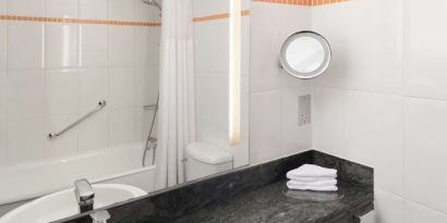 Guest bathroom with shower at Hilton London Kensington.
