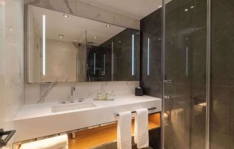 Guest bathroom with shower at Hilton London Metropole. 