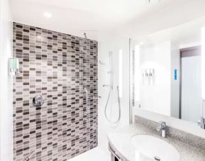 Guest bathroom with shower at Hampton By Hilton Hamilton Park. 