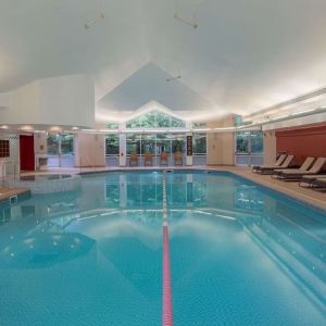 Indoor pool with lounge chairs at Hilton Leicester.