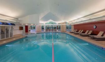 Indoor pool with lounge chairs at Hilton Leicester.