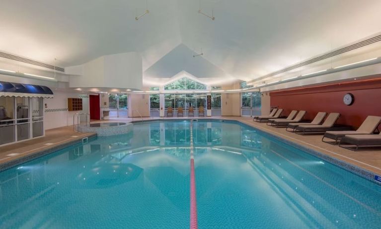 Indoor pool with lounge chairs at Hilton Leicester.