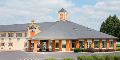 Parking and hotel exterior at Baymont By Wyndham Pella.