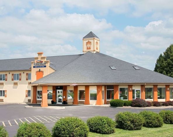 Parking and hotel exterior at Baymont By Wyndham Pella.