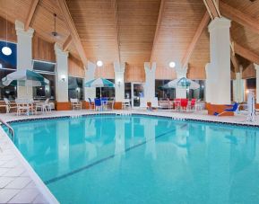 Indoor pool with seating area at Baymont By Wyndham Pella.