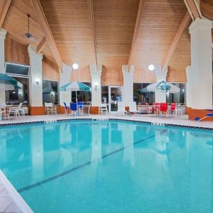 Indoor pool with seating area at Baymont By Wyndham Pella.