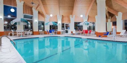 Indoor pool with seating area at Baymont By Wyndham Pella.