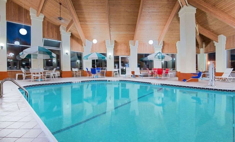 Indoor pool with seating area at Baymont By Wyndham Pella.