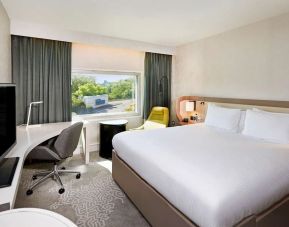 King bedroom with work desk at Hilton London Heathrow Airport.