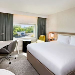 King bedroom with work desk at Hilton London Heathrow Airport.