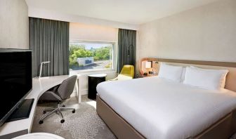 King bedroom with work desk at Hilton London Heathrow Airport.