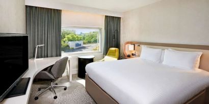 King bedroom with work desk at Hilton London Heathrow Airport.