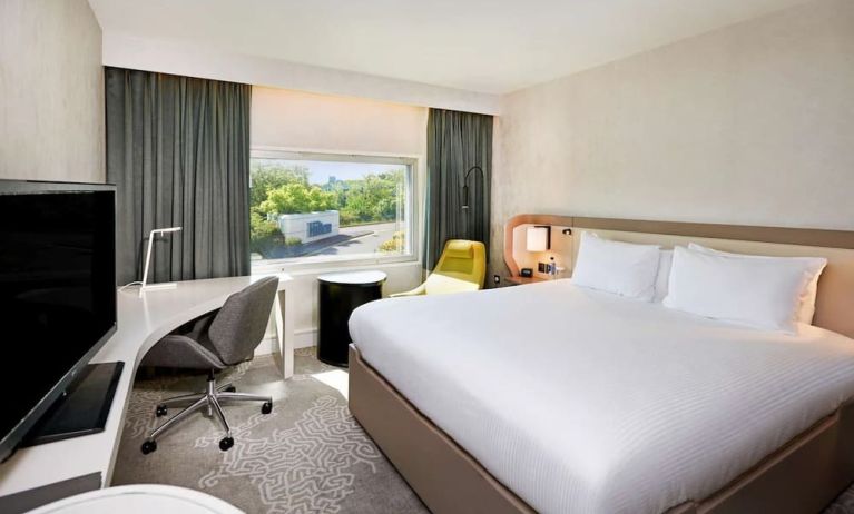 King bedroom with work desk at Hilton London Heathrow Airport.